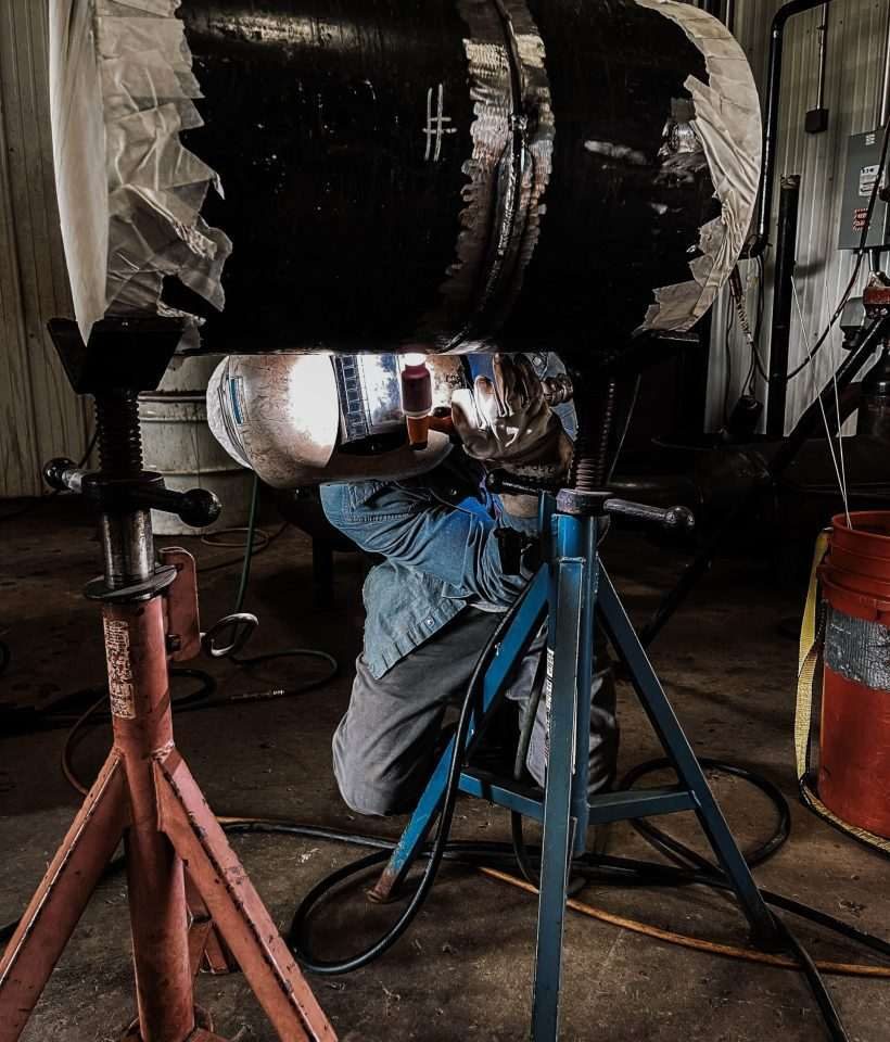 Welding instructor demonstrating welding techniques to students during hands-on training at KWI
